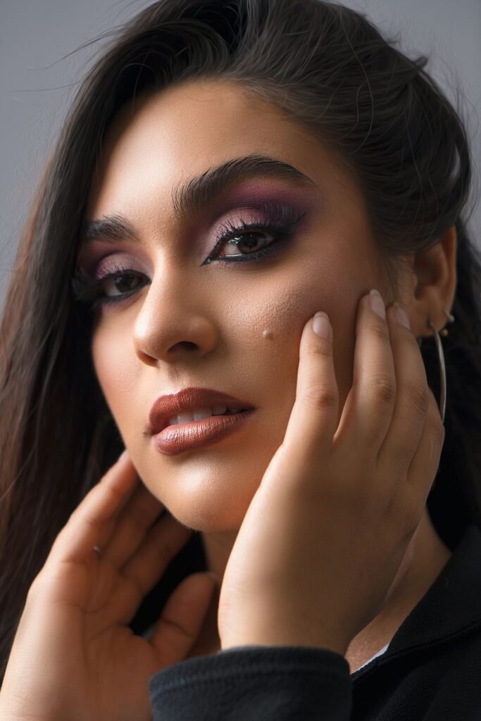 Mujer con las manos sobre el rostro, piel luminosa y maquillaje natural